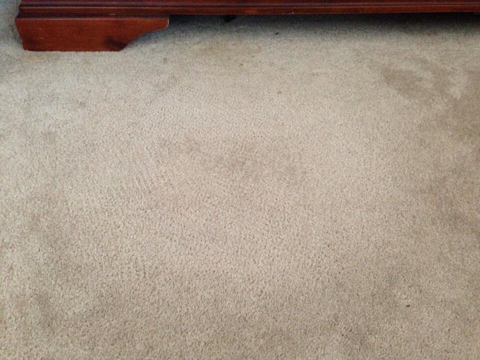 Repaired bedroom carpet after patching, with the damaged section replaced