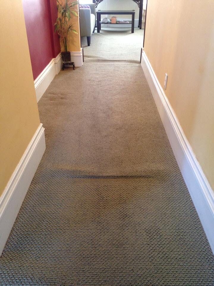 Hallway carpet with pronounced ripples along its length before restretching