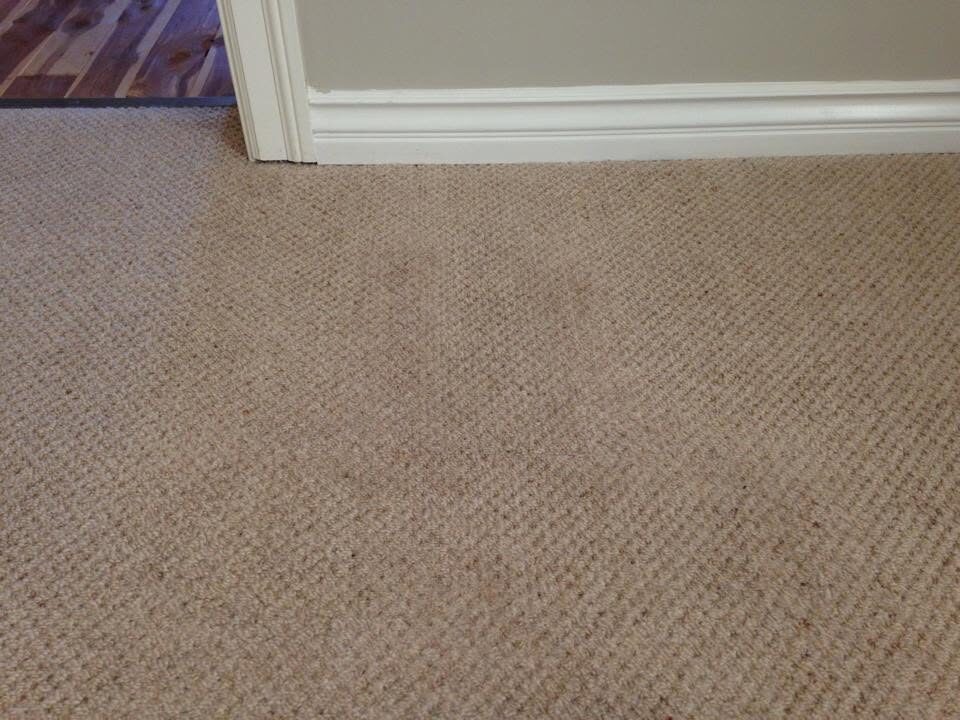 Doorway area with new carpet patch blended in after repair of a missing section